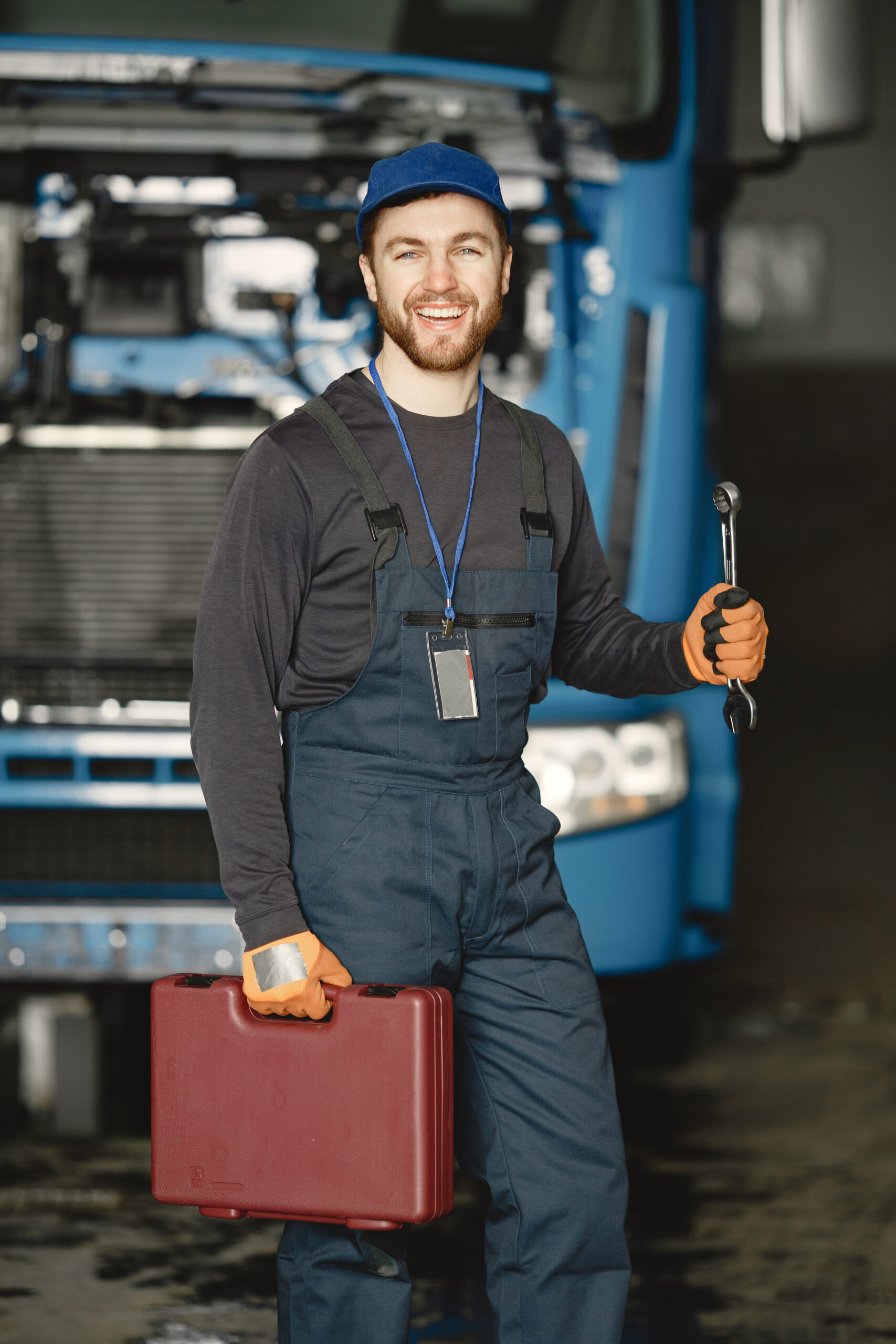 young worker in uniform near truck with tools